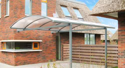 Gebogen carport tegen woning aan